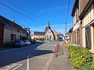a small town street with a church in the background at L'escale de Blacourt in Blacourt