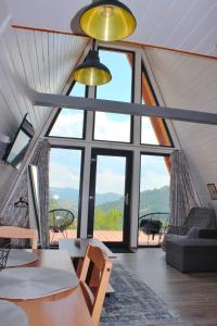 a living room with a large window in a house at Cabana Magia Apusenilor in Arada