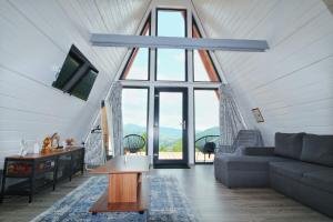 a living room with a couch and a large window at Cabana Magia Apusenilor in Arada