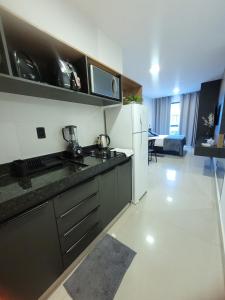 a kitchen with a sink and a refrigerator at Modern Studio 102 proximo Anashoping in Anápolis +10 photos