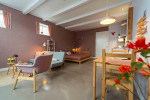 a living room with a couch and a bed and a table at Het arrangement in Wemeldinge
