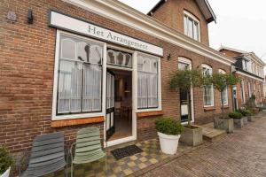 a store with chairs outside of a brick building at Het arrangement in Wemeldinge