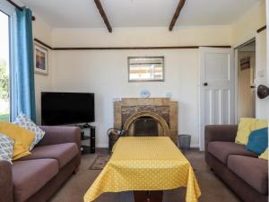 a living room with two couches and a fireplace at Highdown in Bigbury on Sea