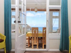 a dining room with a table and a view of the ocean at Highdown in Bigbury on Sea +31 photos