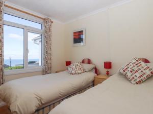 two beds in a room with a window at Highdown in Bigbury on Sea