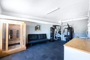 a living room with a black couch in a garage at 5BR - The Boulevarde Miranda - Parking in Miranda