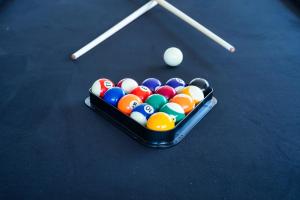 a bowl of billiard balls on a pool table at 5BR - The Boulevarde Miranda - Parking in Miranda