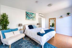 a bedroom with a bed and a chair at 5BR - The Boulevarde Miranda - Parking in Miranda