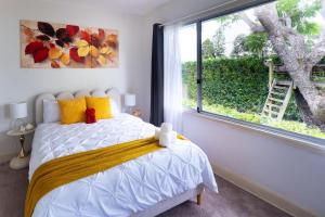 a bedroom with a bed and a large window at 5BR - The Boulevarde Miranda - Parking in Miranda +30 photos