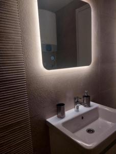 a bathroom with a sink and a mirror at Aria Apartmani in Podgorica +13 photos