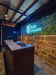 a kitchen with a counter and a sign on a wall at Glamping villeta campo heliconias in Villeta