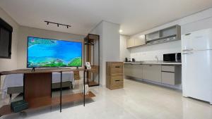 a kitchen with a large screen television on a desk at Urban Stay Botanic in Goiânia +88 photos