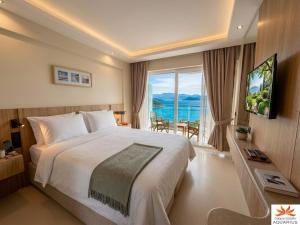 a bedroom with a large bed and a large window at Aquarius Hotel in Kaş