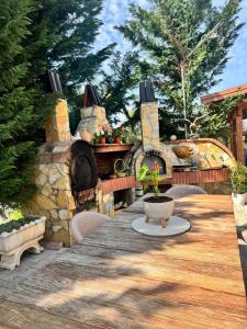 a patio with a stone fireplace and a pizza oven at Alesia's Guesthouse in Vlorë