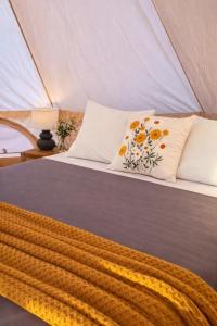 a bed in a tent with flowers on it at Monte da Tojeirinha in Montargil +99 photos