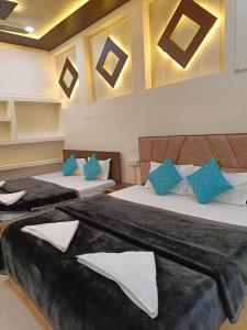 two beds in a room with blue and white pillows at The Mystery Hostel in Varanasi +23 photos