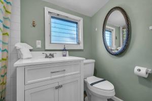 a bathroom with a white toilet and a mirror at Fast Wi-Fi | Linen & Towel | Coffee | Prof Cleaned in Seaside Park +9 photos