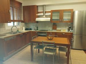 a kitchen with a table and chairs and a refrigerator at Kings and Queens 2 in Larisa
