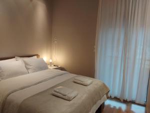 a bedroom with a bed with two towels on it at Kings and Queens 2 in Larisa +44 photos