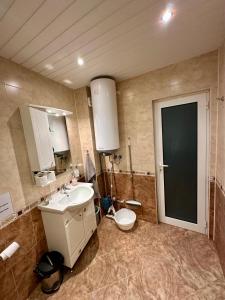 a bathroom with a sink and a toilet and a door at Radetsky Apartment with FREE Private Parking in Haskovo +41 photos