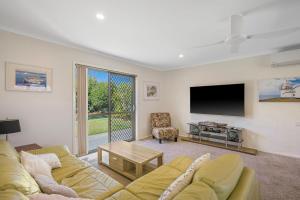 a living room with a couch and a flat screen tv at Francis 31 in Port Macquarie