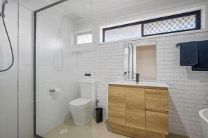 a bathroom with a toilet and a sink and a window at Francis 31 in Port Macquarie +11 photos