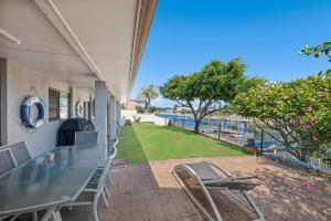a patio with a table and chairs and a view of the water at Francis 31 in Port Macquarie