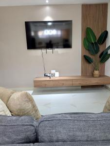 a living room with a couch and a flat screen tv at Salt & Breeze Villa in Priory