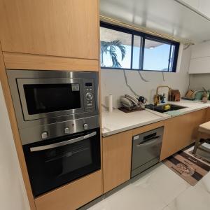 a kitchen with a microwave oven and a sink at Salt & Breeze Villa in Priory