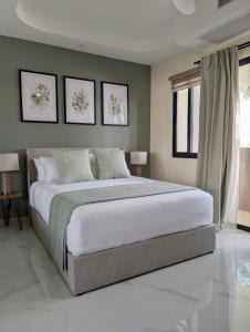 a bedroom with a large bed with three pictures on the wall at Salt & Breeze Villa in Priory +28 photos