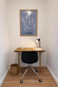 a wooden desk with a black chair and a lamp at Altbau Apartment mit toller Terrasse in Mülheim an der Ruhr +11 photos