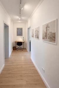 a hallway with white walls and a desk in a room at Altbau Apartment mit toller Terrasse in Mülheim an der Ruhr