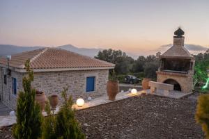a stone house with a fireplace and a building at Bellus Residence! in Ambeloúzos