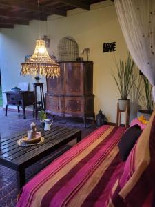 a room with a bed and a table and a chandelier at La Perdida Casa de Campo in San Antonio de Areco