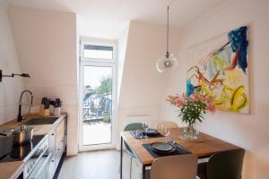 a kitchen with a table with a vase of flowers on it at Altbau Apartment mit toller Terrasse in Mülheim an der Ruhr