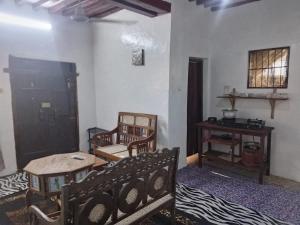 a living room with a couch and a table at Precious Bungalow House in Lamu