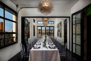 a long table in a room with chairs and a chandelier at The 121 Hotel in Nashville