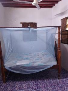 a bed with a canopy in a room at Precious Bungalow House in Lamu