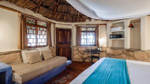 a bedroom with a bed and a couch in a room at Zamas Hotel in Tulum