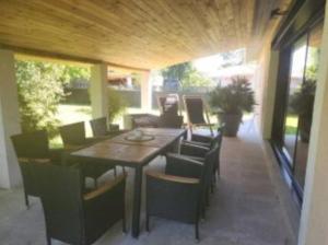a patio with a wooden table and chairs at Villa cosy in Biganos