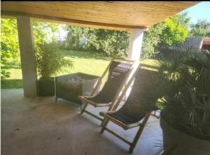 two rocking chairs on a patio with a porch at Villa cosy in Biganos