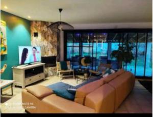 a living room with a couch and a television at Villa cosy in Biganos