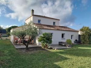 a large white house with a grass yard at Suite parentale chez Mathilde in Basse-Goulaine