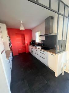 a kitchen with red walls and a red door at Suite parentale chez Mathilde in Basse-Goulaine +1 photo