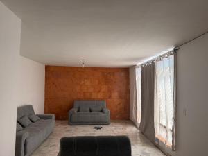 a living room with two couches and a large window at Casa a 5 min del perímetro ferial in Aguascalientes