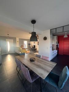 a kitchen and living room with a wooden table and chairs at Suite parentale chez Mathilde in Basse-Goulaine