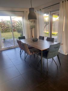 a dining room with a wooden table and chairs at Suite parentale chez Mathilde in Basse-Goulaine