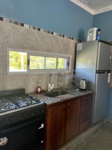a kitchen with a stove and a refrigerator at Casa en la Puntilla 2 in Belén