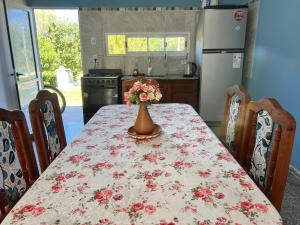 a kitchen with a table with a vase of flowers on it at Casa en la Puntilla 2 in Belén +2 photos