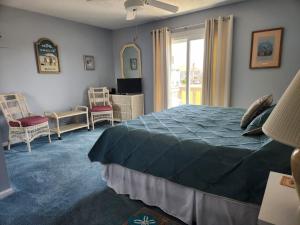 ein Schlafzimmer mit Bett, Stühlen und einem Fenster in der Unterkunft Outer Banks in Kitty Hawk
